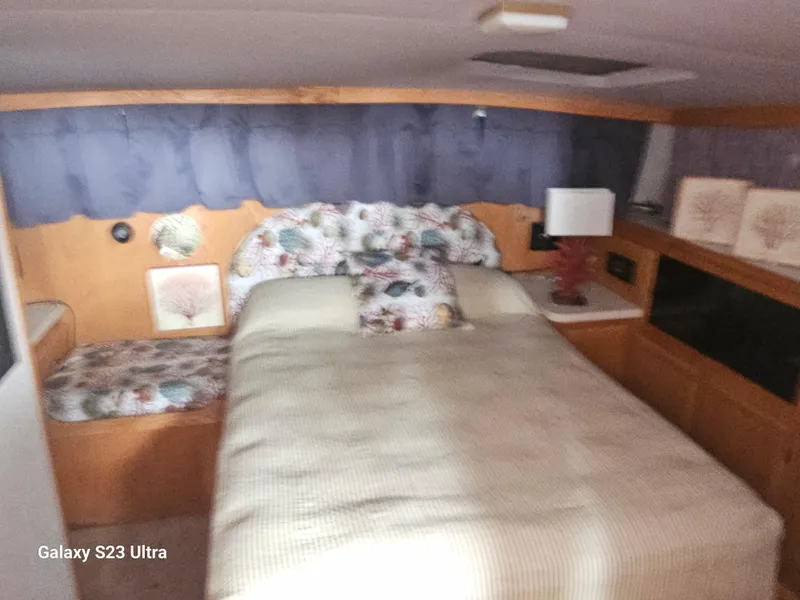 Slide: The Image of 1989 Silverton 40 Aft Cabin bedroom with floral decor and cozy bedding. - 11