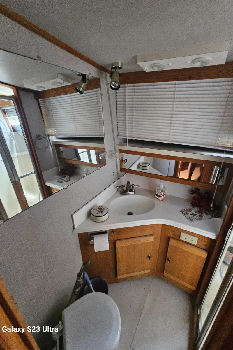 Slide: The Image of 1989 Silverton 40 Aft Cabin bathroom with sink, mirror, and wooden cabinets. - 16