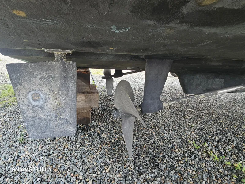 Slide: The Image of 1989 Silverton 40 Aft Cabin boat propeller and rudder on gravel. - 18