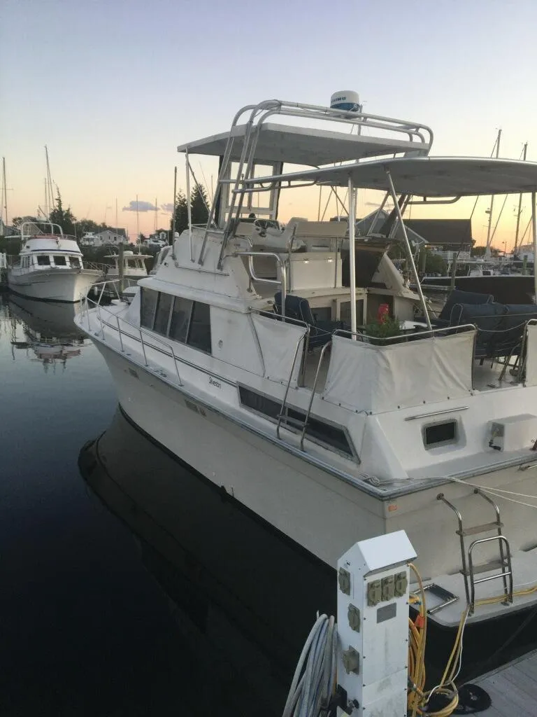Slide: The Image of 1989 Silverton 40 Aft Cabin yacht docked at sunset in a marina. - 2