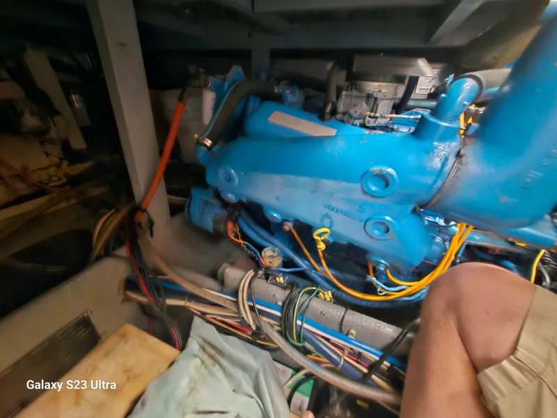Slide: The Image of Engine room of 1989 Silverton 40 Aft Cabin with visible blue engine components. - 24