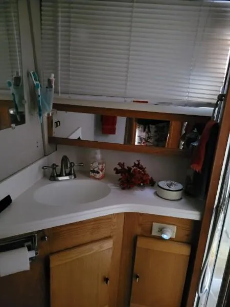Slide: The Image of 1989 Silverton 40 Aft Cabin bathroom with sink, mirror, and wooden cabinets. - 28