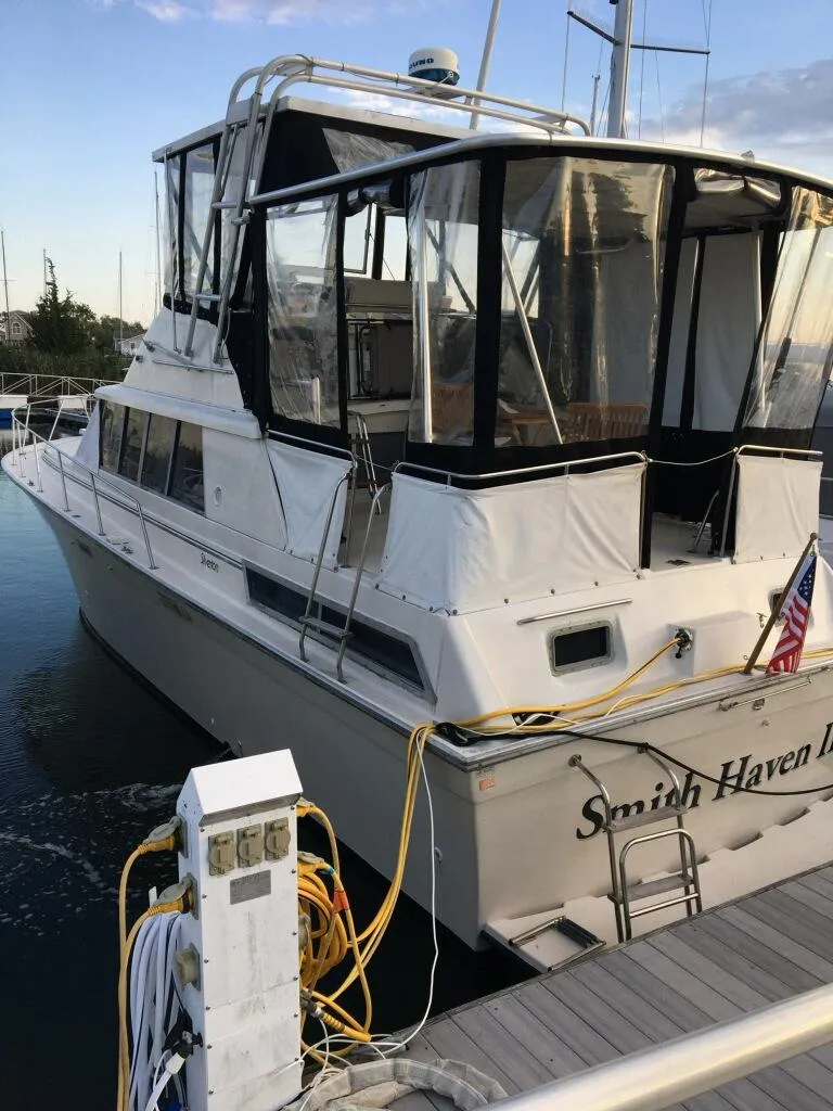 Slide: The Image of 1989 Silverton 40 Aft Cabin yacht docked at marina with clear skies. - 3