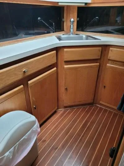 Slide: The Image of 1989 Silverton 40 Aft Cabin kitchen with wood cabinets and flooring. - 33
