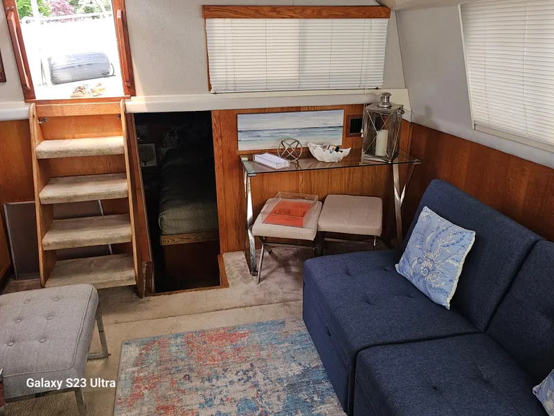 Slide: The Image of 1989 Silverton 40 Aft Cabin interior with blue sofa, stairs, and decorative accents. - 8