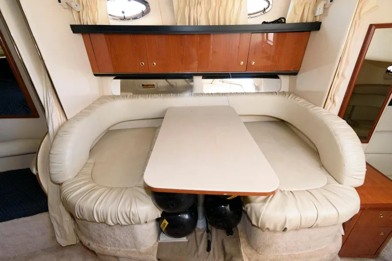 Slide: The Image of 1999 Sea Ray 340 Sundancer cabin with U-shaped seating and dining table. - 11
