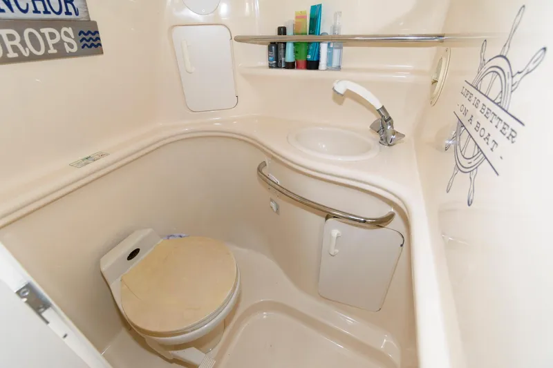 Slide: The Image of 1999 Sea Ray 340 Sundancer bathroom with sink, toilet, and storage cabinets. - 14