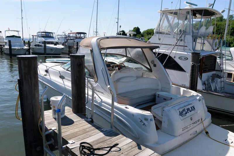 Slide: The Image of 1999 Sea Ray 340 Sundancer docked at a marina with other boats. - 2
