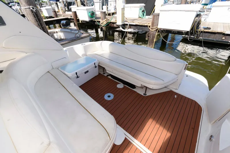 Slide: The Image of 1999 Sea Ray 340 Sundancer boat deck with white seating and wooden flooring. - 5