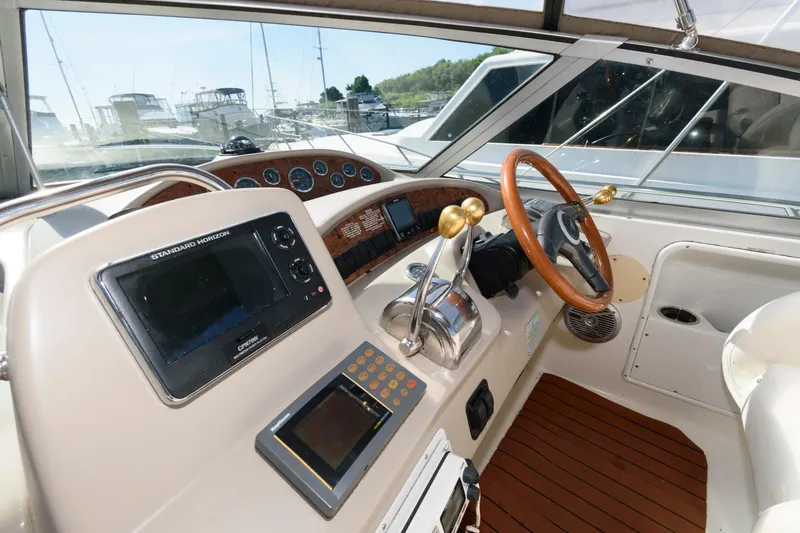 Slide: The Image of Cockpit of 1999 Sea Ray 340 Sundancer with navigation equipment and wooden steering wheel. - 7