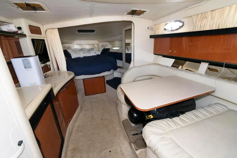 Slide: The Image of 1999 Sea Ray 340 Sundancer interior with kitchen, dining area, and sleeping quarters. - 9