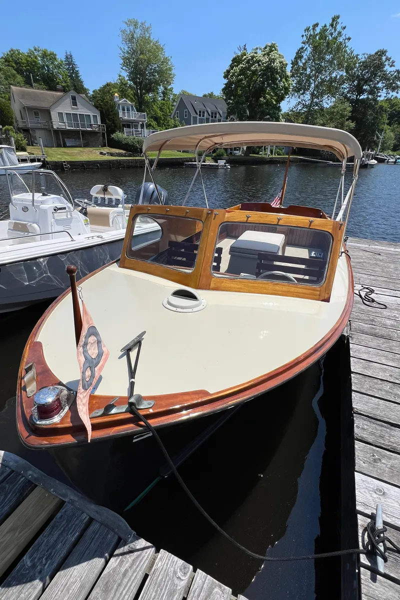 Slide: The Image of 1952 Custom Palmer Scott 22 boat docked by a serene lakeside. - 1