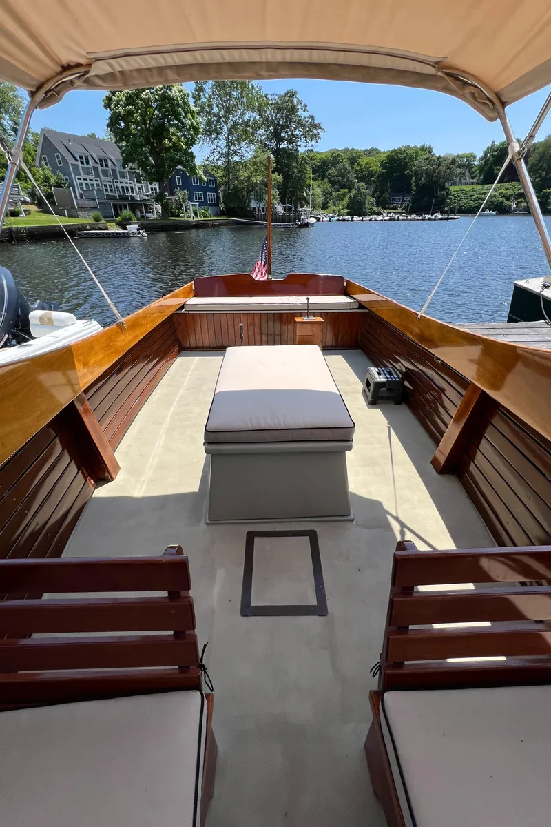 Slide: The Image of 1952 Custom Palmer Scott 22 boat with wooden interior, docked on a serene lake. - 10