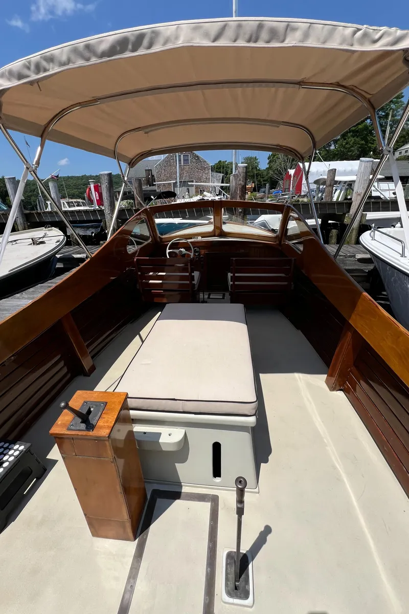 Slide: The Image of 1952 Custom Palmer Scott 22 boat with canopy, wooden interior, and docked at a marina. - 11