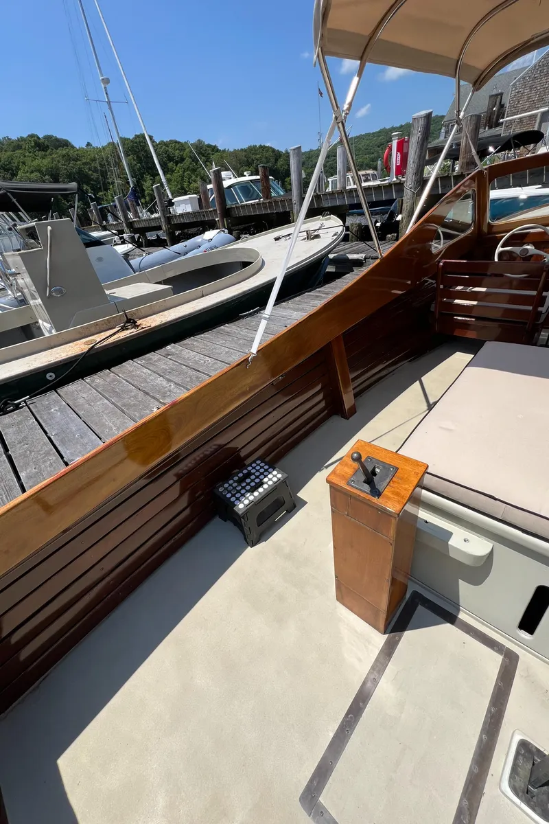 Slide: The Image of 1952 Custom Palmer Scott 22 boat interior with wooden details and docked at marina. - 14