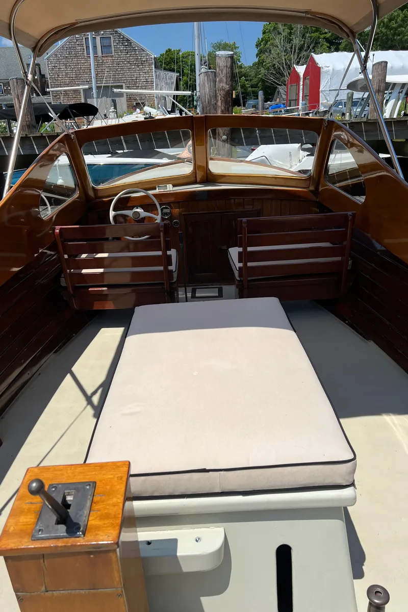 Slide: The Image of 1952 Custom Palmer Scott 22 boat interior with wooden accents and cushioned seating. - 15