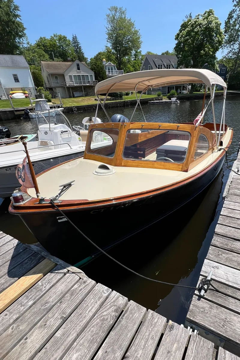 Slide: The Image of 1952 Custom Palmer Scott 22 boat docked, featuring classic wooden design and canopy. - 2