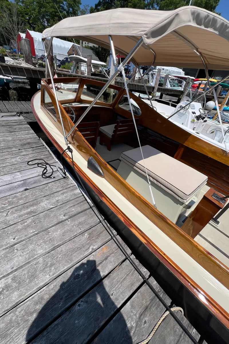 Slide: The Image of 1952 Custom Palmer Scott 22 boat docked, featuring wooden details and a beige canopy. - 4