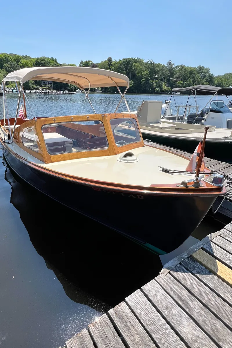Slide: The Image of 1952 Custom Palmer Scott 22 boat docked on a sunny day by the lake. - 5