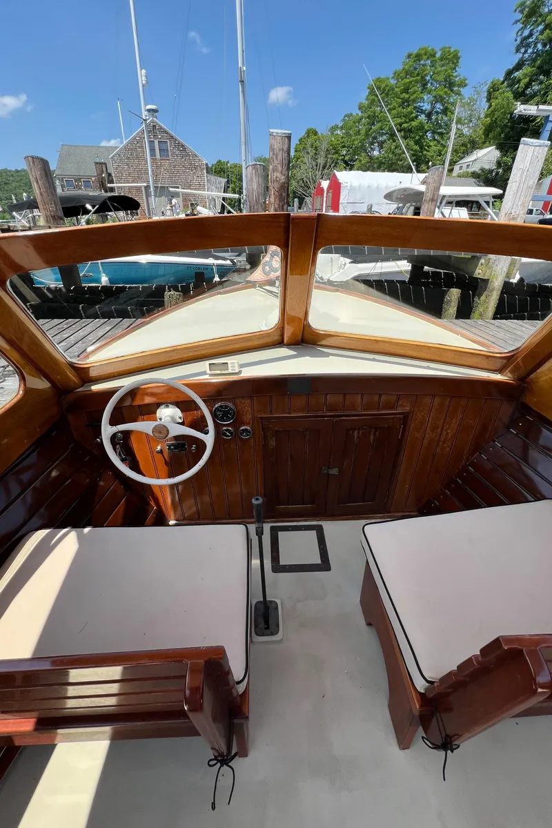 Slide: The Image of 1952 Custom Palmer Scott 22 boat interior with wooden dashboard and white steering wheel. - 7