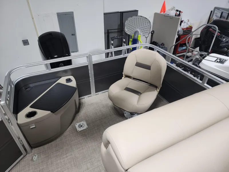 Slide: The Image of 2024 Sun Tracker Fishin' Barge 20 DLX interior with beige seating and storage. - 12