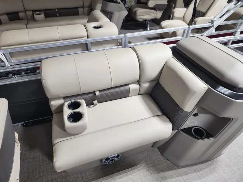 Slide: The Image of 2024 Sun Tracker Fishin' Barge 20 DLX interior with beige seating and cup holders. - 6