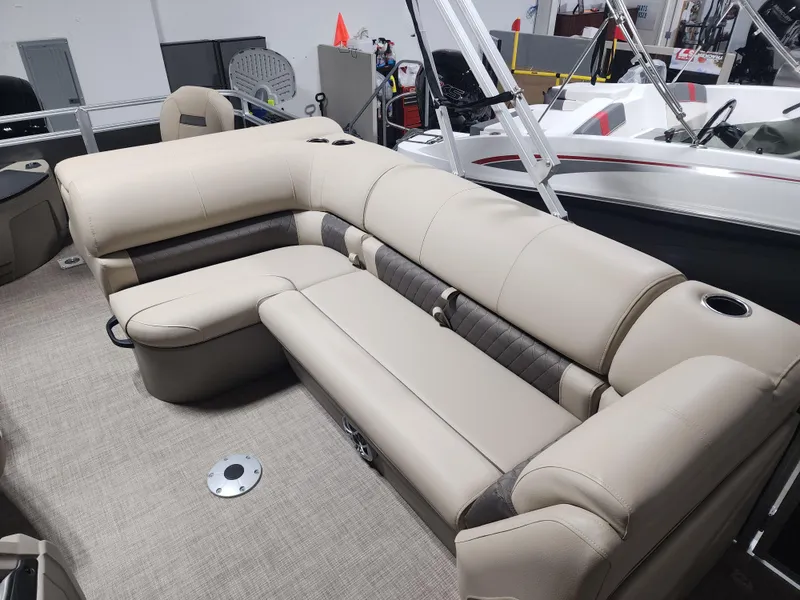 Slide: The Image of 2024 Sun Tracker Fishin' Barge 20 DLX interior with beige seating and cup holders. - 8