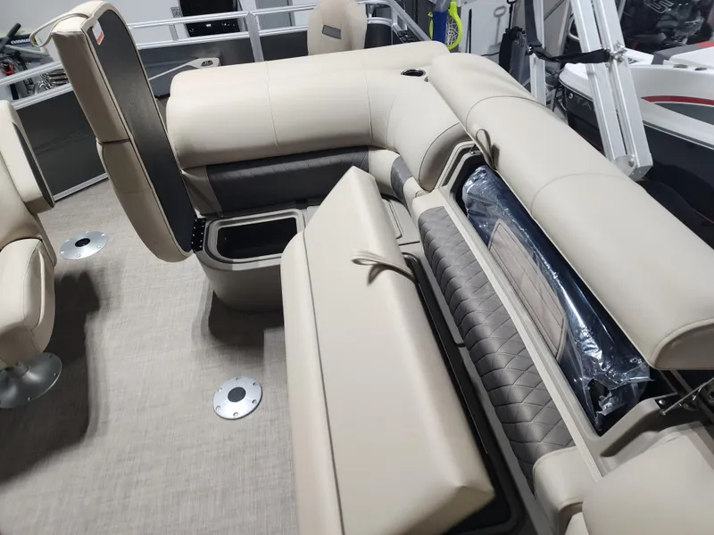 Slide: The Image of 2024 Sun Tracker Fishin' Barge 20 DLX interior with beige seating and storage compartments. - 9