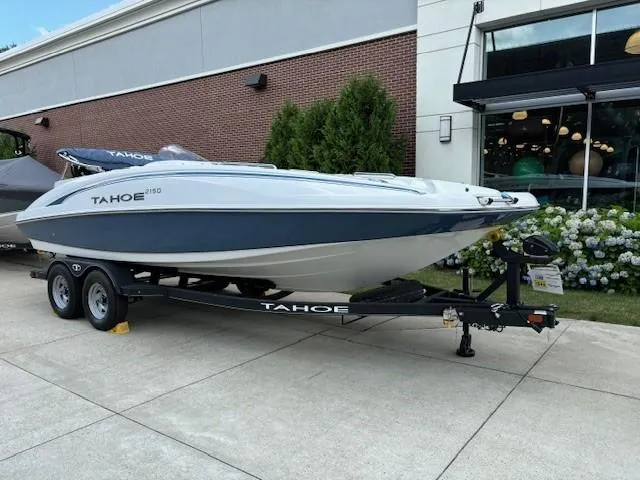 Slide: The Image of 2024 Tahoe 2150 boat on trailer outside a building. - 0