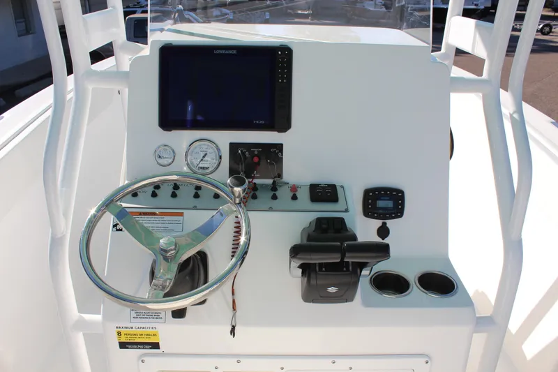 Slide: The Image of 2024 Clearwater 2300 WI boat dashboard with steering wheel, gauges, and navigation system. - 17