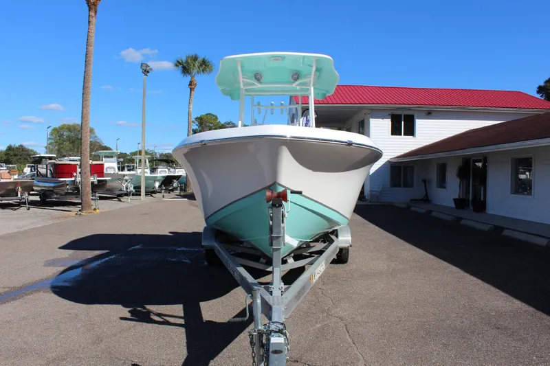 Slide: The Image of 2024 Clearwater 2300 WI boat on trailer in marina parking lot. - 2