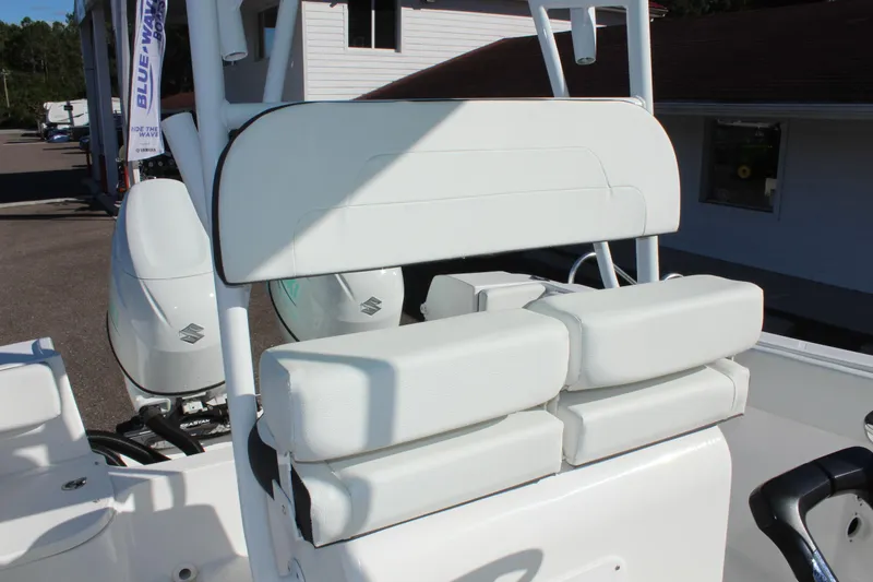 Slide: The Image of Clearwater 2300 WI 2024 boat seating and console area with white upholstery. - 21