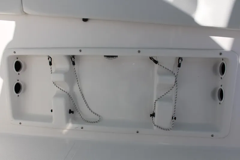 Slide: The Image of 2024 Clearwater 2300 WI boat storage compartment with securing straps. - 30