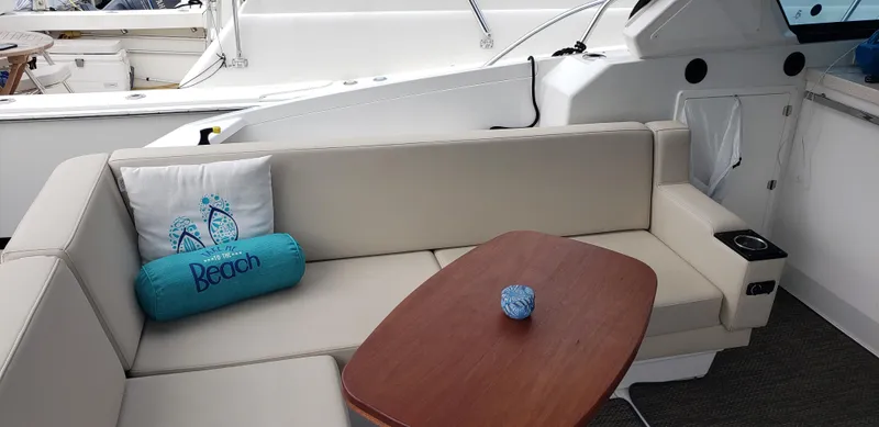 Slide: The Image of 2016 Monterey 360 Sport Coupe interior with beige seating and wooden table. - 25