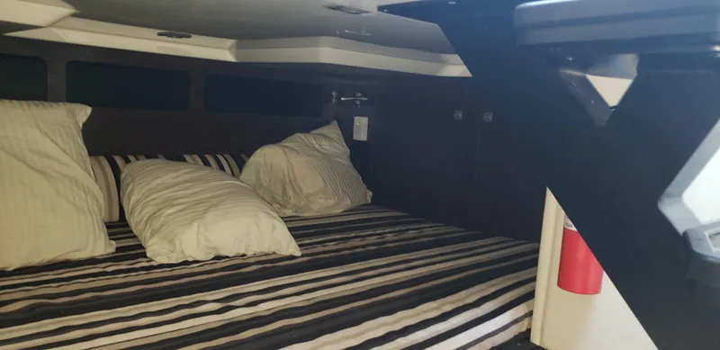 Slide: The Image of Interior cabin of 2016 Monterey 360 Sport Coupe with striped bedding and pillows. - 31