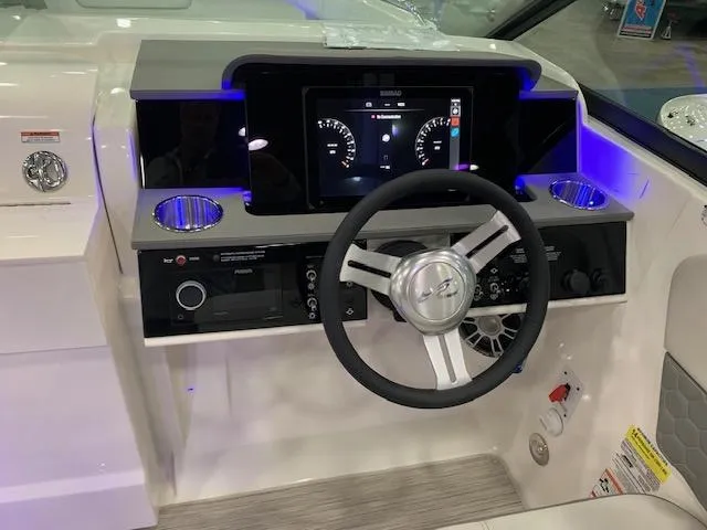 Slide: The Image of 2024 Sea Ray SDX 250 boat dashboard with steering wheel and digital display. - 2