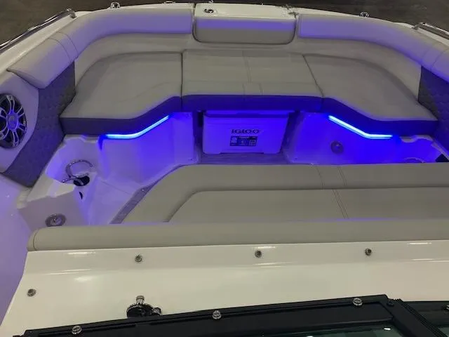 Slide: The Image of 2024 Sea Ray SDX 250 boat interior with blue LED lighting and cushioned seating. - 7