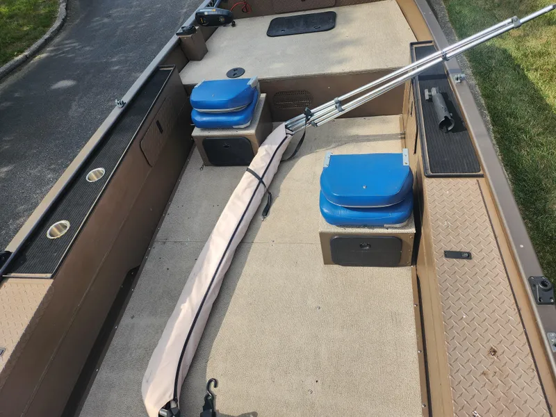 Slide: The Image of 2015 Smoker Craft Sportsman Pro 1866 boat interior with blue seats and fishing rod. - 11