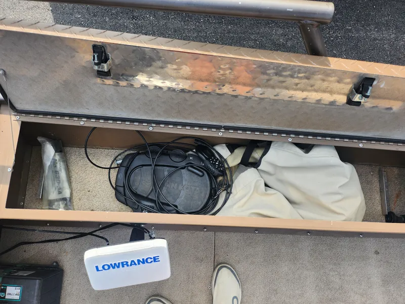 Slide: The Image of Open storage compartment of 2015 Smoker Craft Sportsman Pro 1866 boat with Lowrance equipment. - 19