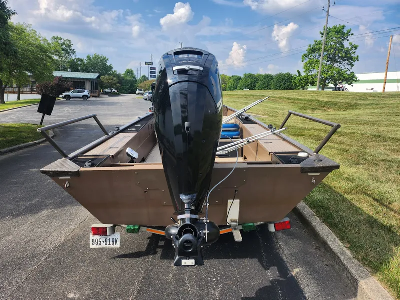 Slide: The Image of 2015 Smoker Craft Sportsman Pro 1866 boat with outboard motor, parked on a sunny day. - 2