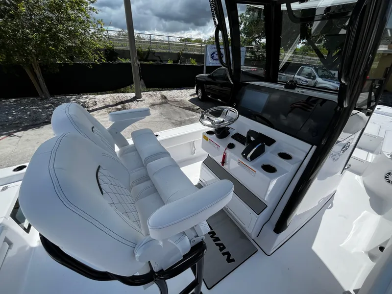 Slide: The Image of 2024 Sportsman Masters 247 Bay Boat cockpit with dual white seats and modern controls. - 12