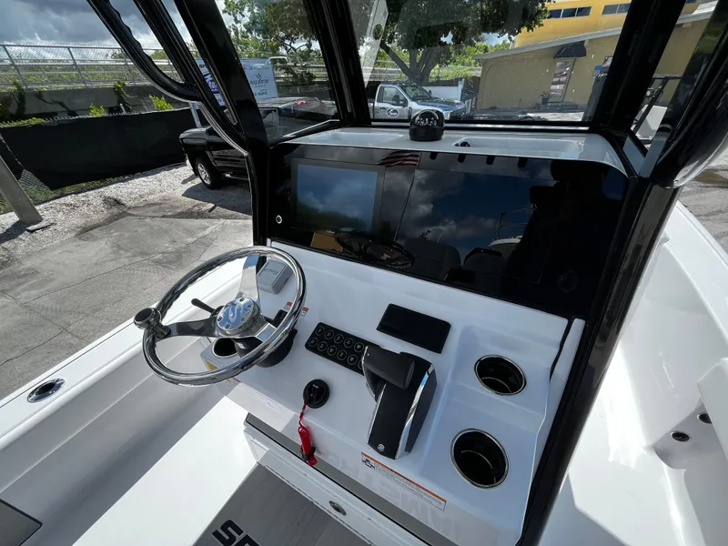 Slide: The Image of 2024 Sportsman Masters 247 Bay Boat console with steering wheel and control panel. - 13
