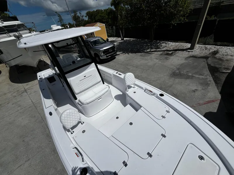 Slide: The Image of 2024 Sportsman Masters 247 Bay Boat with white interior, docked on a sunny day. - 24