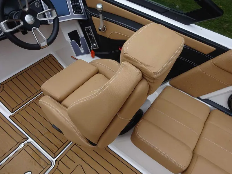 Slide: The Image of 2022 MasterCraft XT23 boat interior with tan leather seats and wood flooring. - 10