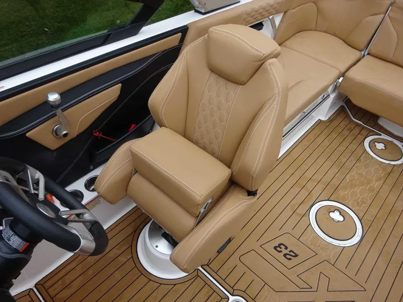 Slide: The Image of 2022 MasterCraft XT23 boat interior with tan leather seats and teak flooring. - 11