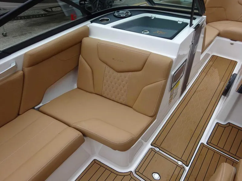 Slide: The Image of 2022 MasterCraft XT23 boat interior with tan leather seats and teak flooring. - 12