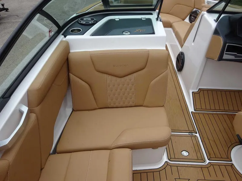 Slide: The Image of 2022 MasterCraft XT23 boat interior with tan leather seats and teak flooring. - 13