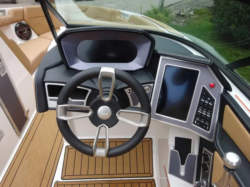 Slide: The Image of 2022 MasterCraft XT23 boat dashboard with steering wheel and touchscreen controls. - 14