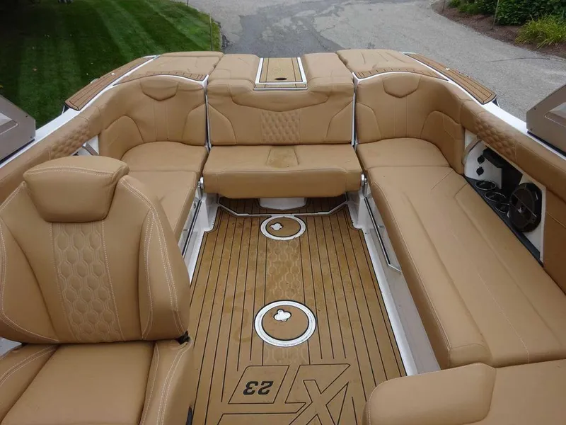 Slide: The Image of 2022 MasterCraft XT23 boat interior with tan leather seating and teak flooring. - 19