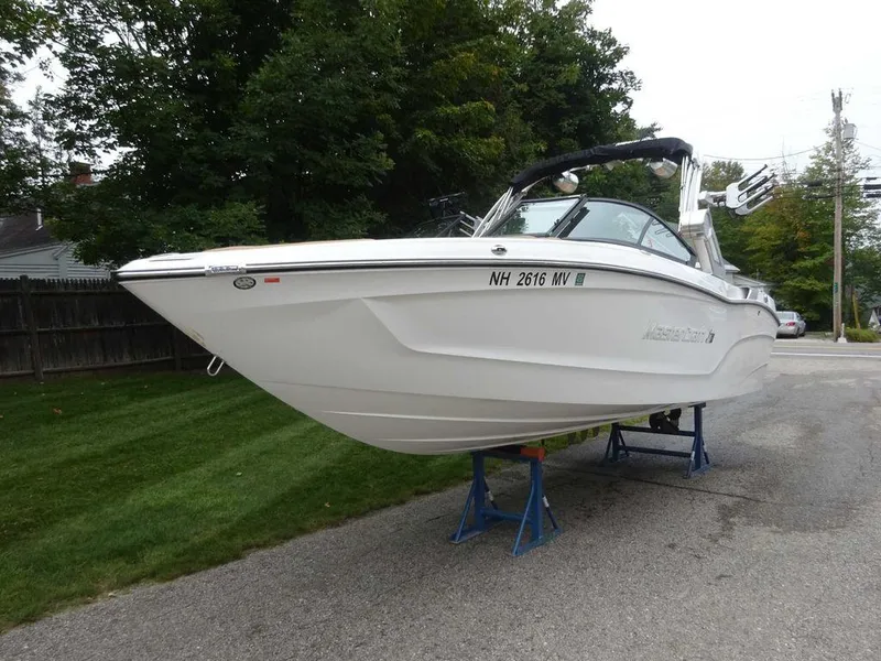 Slide: The Image of 2022 MasterCraft XT23 boat on stands, white hull, parked on a residential street. - 4